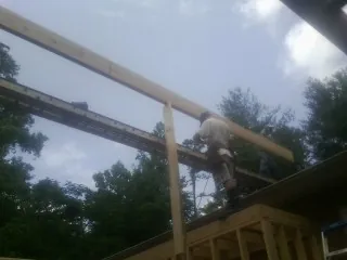 Carpenter setting a ridge beam over a new addition frame — Ice Dam Removal by Roofing Brothers in Limestone