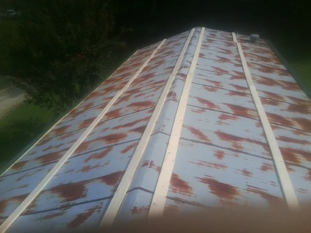Rusted metal roof panels with new wood purlins before replacement — Storm Damage Roof Repair in Limestone by Roofing Brothers